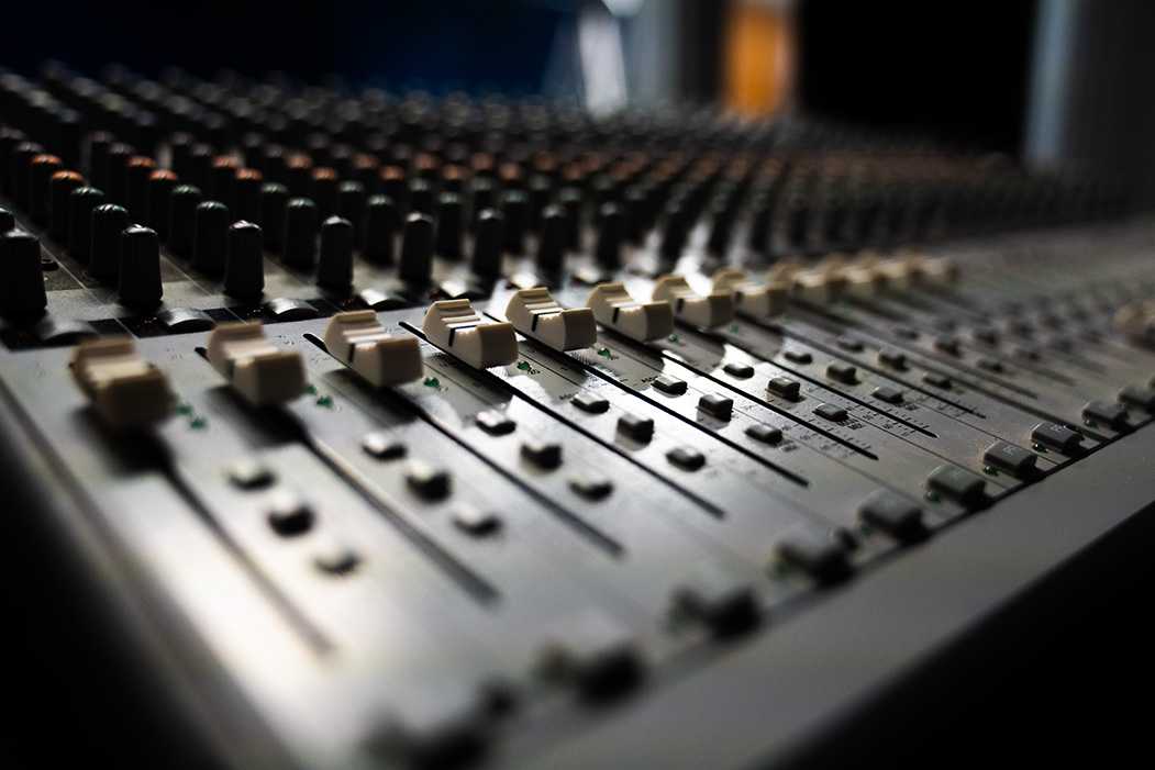 A zoomed in shot of a soundboard's faders.