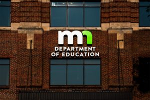 The logo for the Minnesota Department of Education upon their brick exterior headquarters.