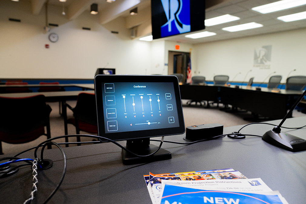 A touch-screen device on top of a table. The screen shows controls for a video control system.