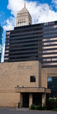 An exterior shot of St. Olaf's Catholic Church in Minneapolis, Minnesota. The Foshay tower can be seen in the background.